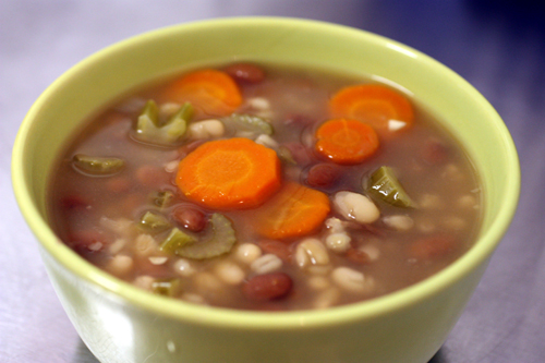 bowl of bean and barley soup with carrots and celery